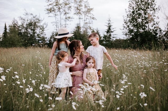 10 Not-So-Obvious Things Every New Mom Needs, Savannah Walsh and her kids in a beautiful field of flowers.